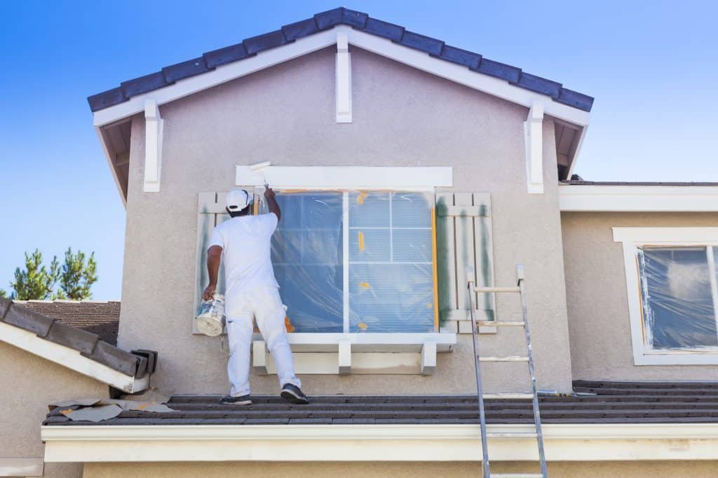 house painter painting the trim of a house