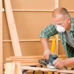 man sanding wood