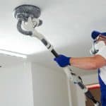 man sanding drywall