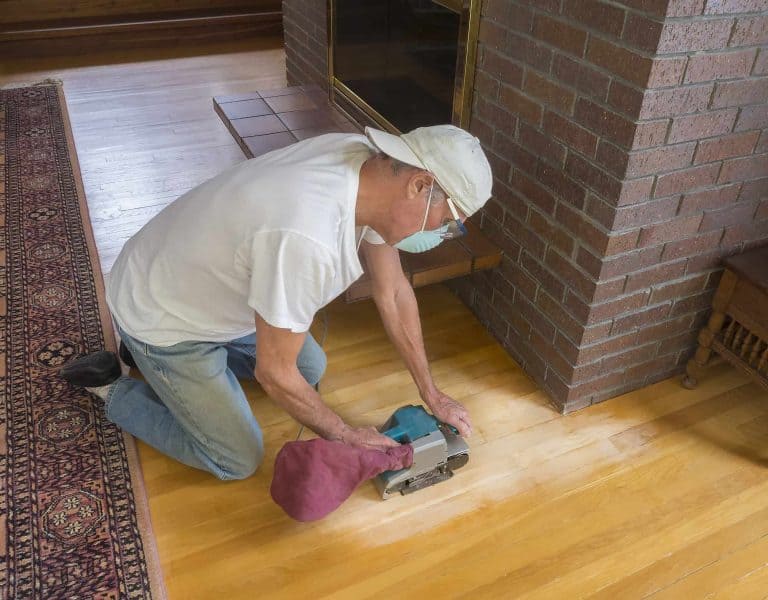 man sanding wooden floor