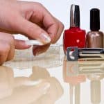 putting on false nails with nail glue and nail polish