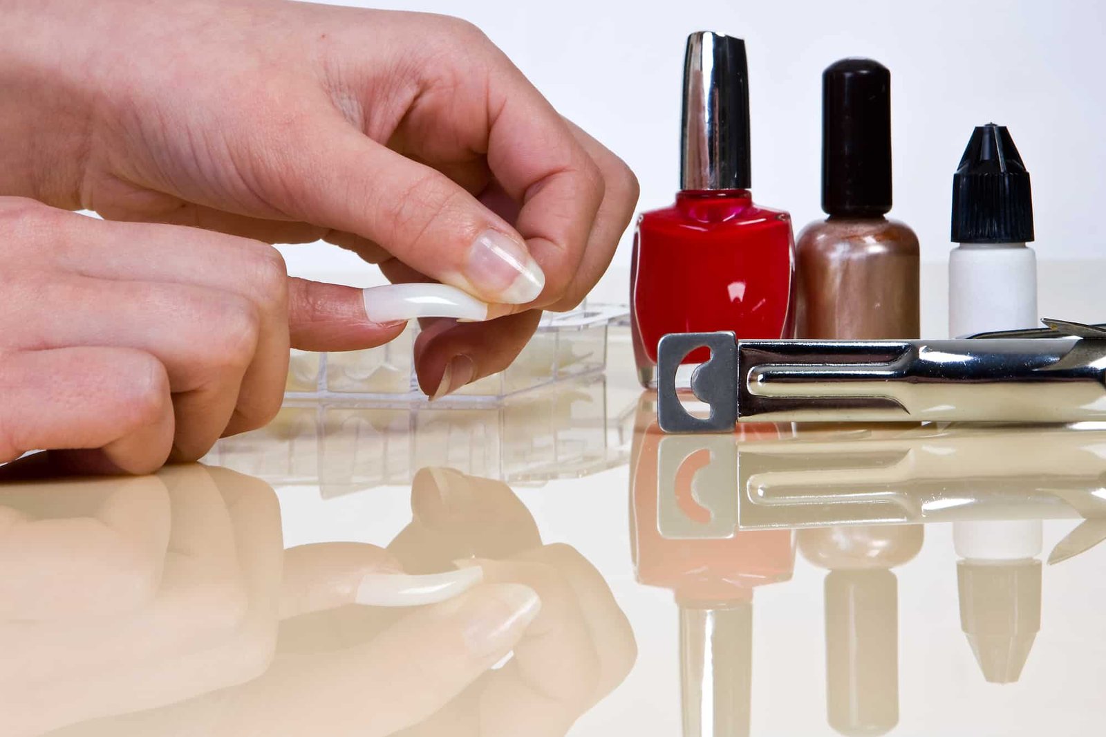 putting on false nails with nail glue and nail polish