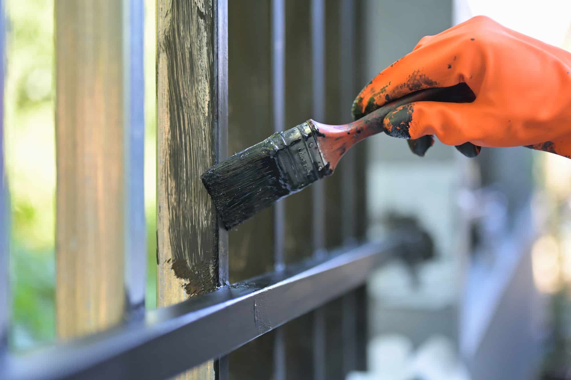 painting the steel gate using a paint brush