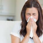 woman is sneezing because of weed-like smell in her house