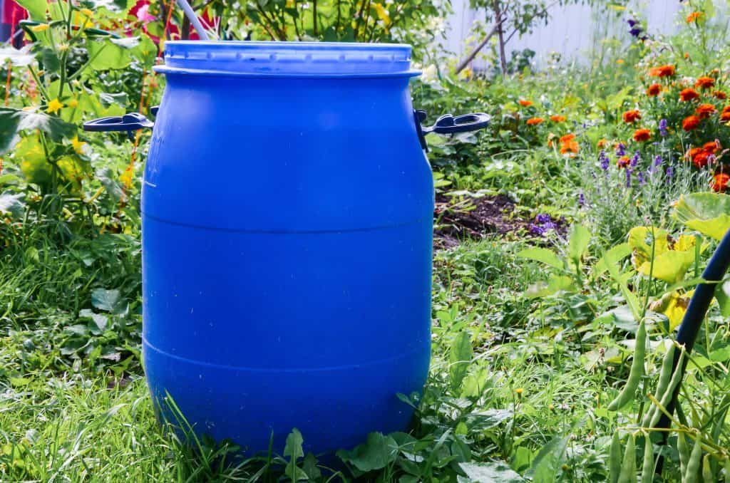 big blue plastic barrel outside the house