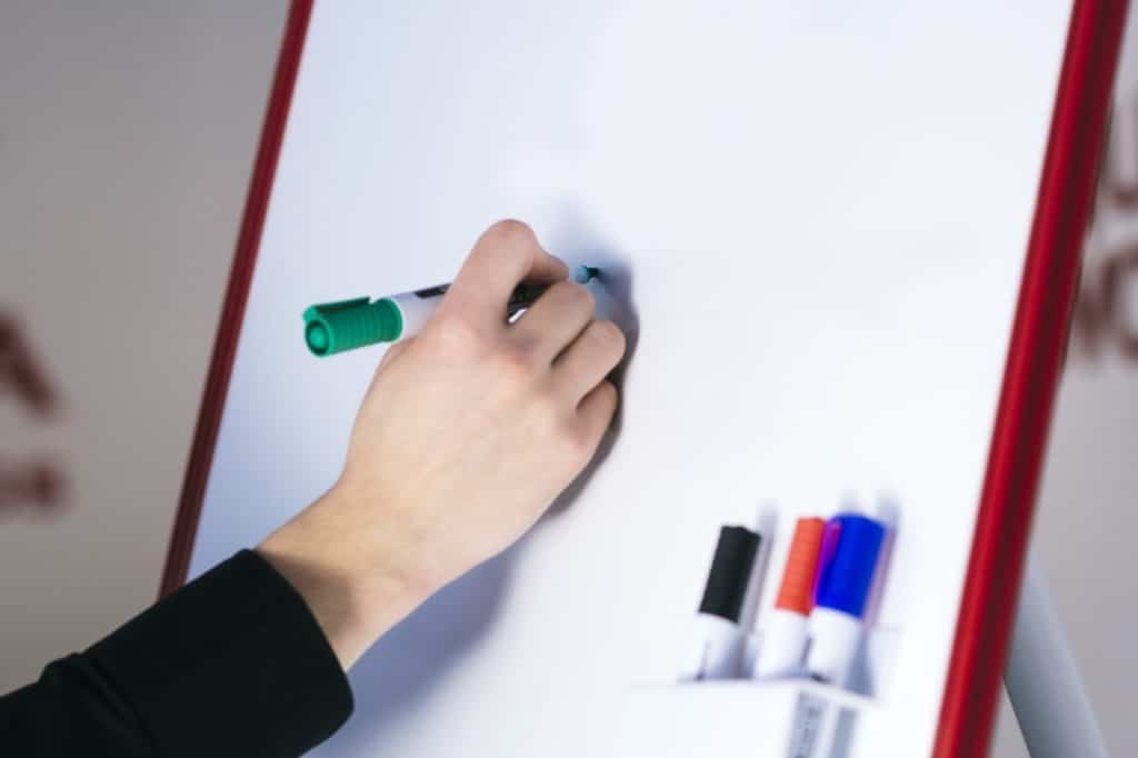 writing on a dry erase board using regular markers