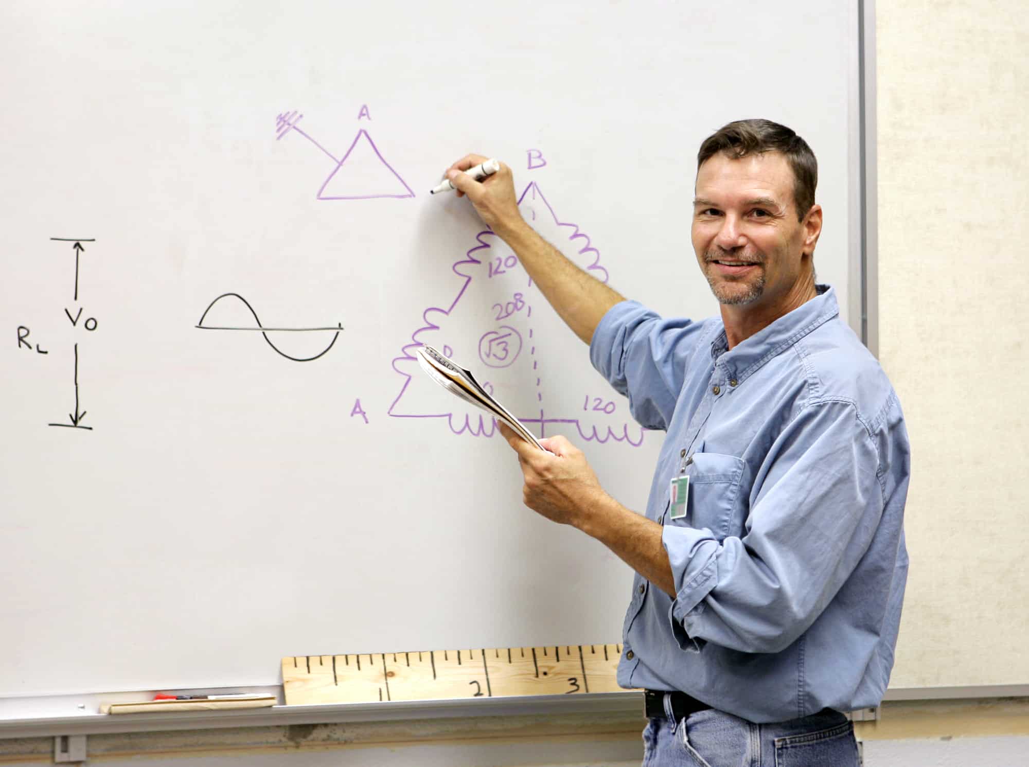 a teacher using a marker to write on a white board