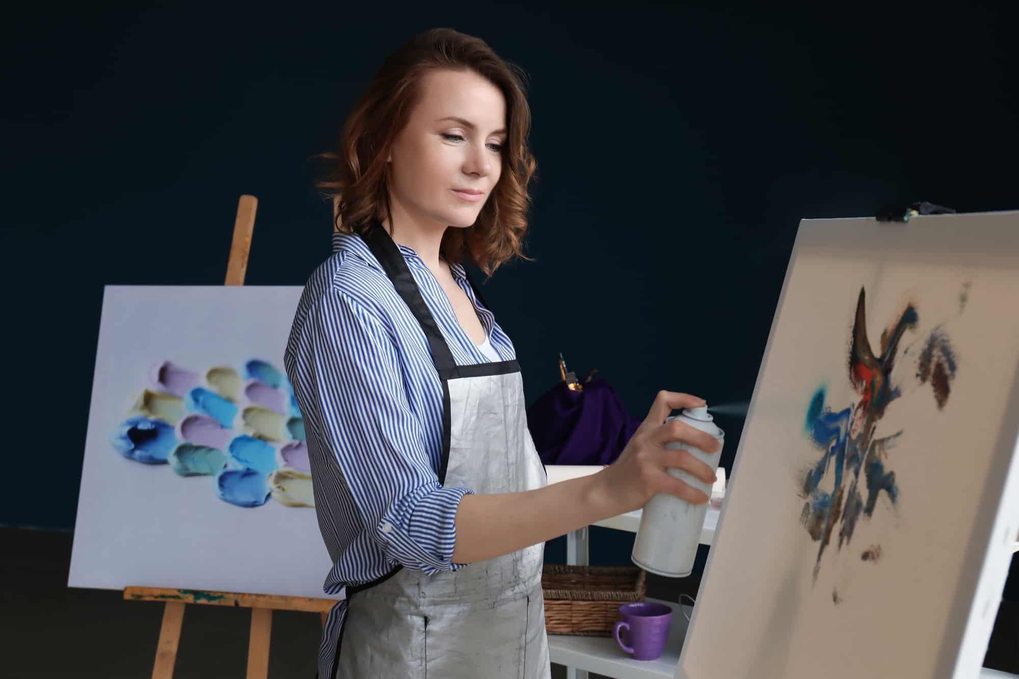 female artist painting using a washable spray paint