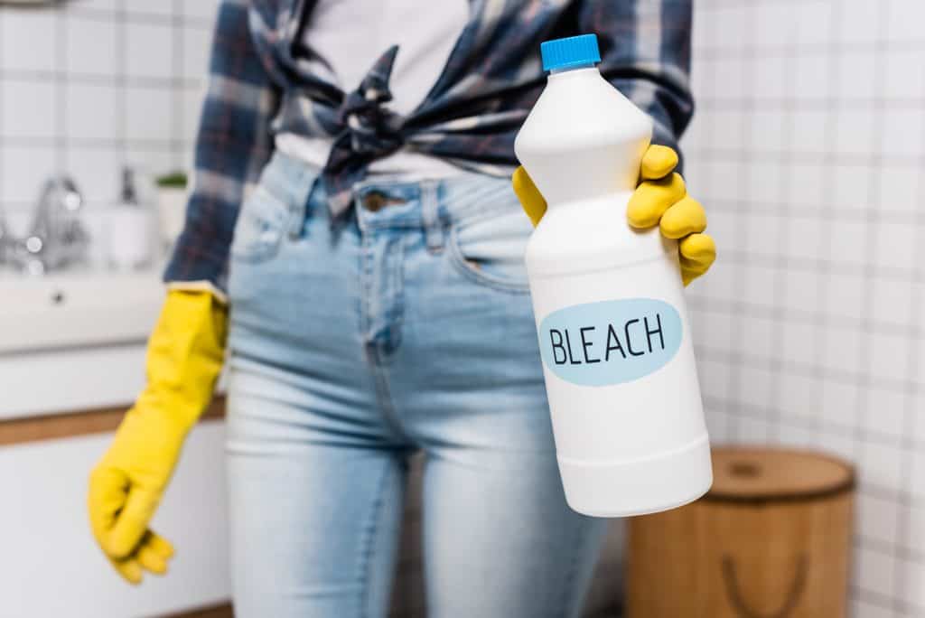 woman holding a gallon of bleach