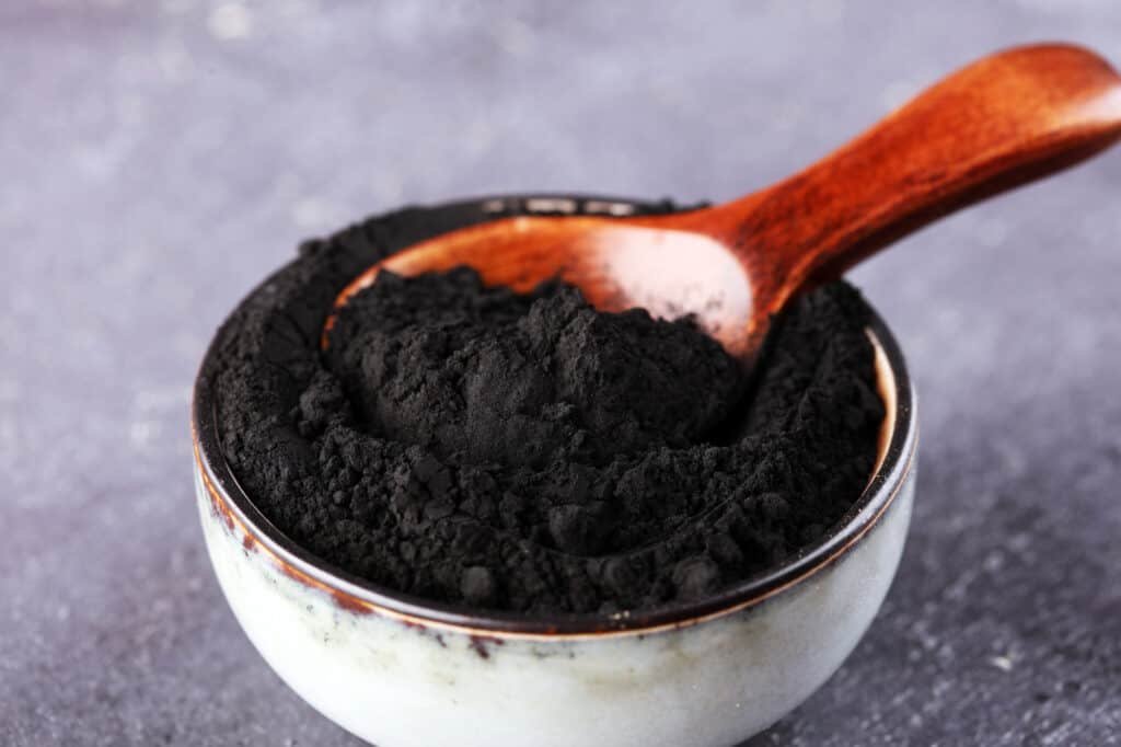 Activated charcoal powder in a white bowl