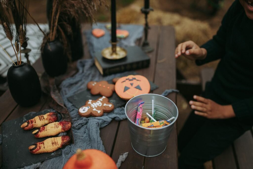 A Person Sitting at a Table with Halloween Decorations and a Bucket of Candies Tips for Halloween