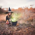 girl in witch costume Halloween decorations