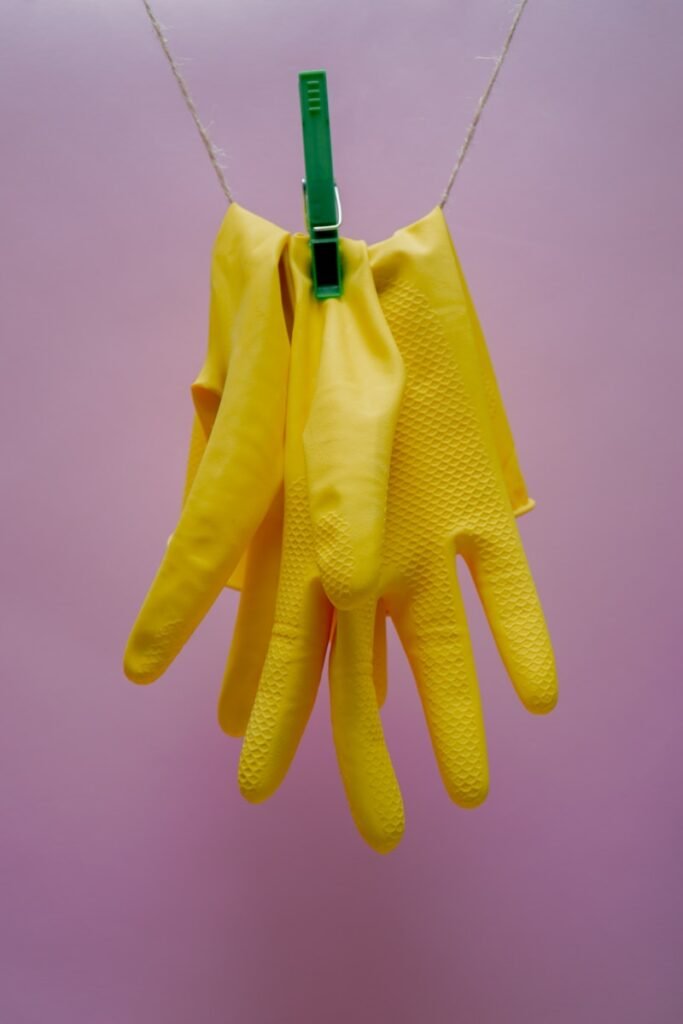 yellow gloves on blue clothes hanger cleaning products